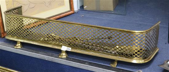 A Regency brass kerb, on octagonal facetted feet, and three similar brass fire irons, Fender 120cm